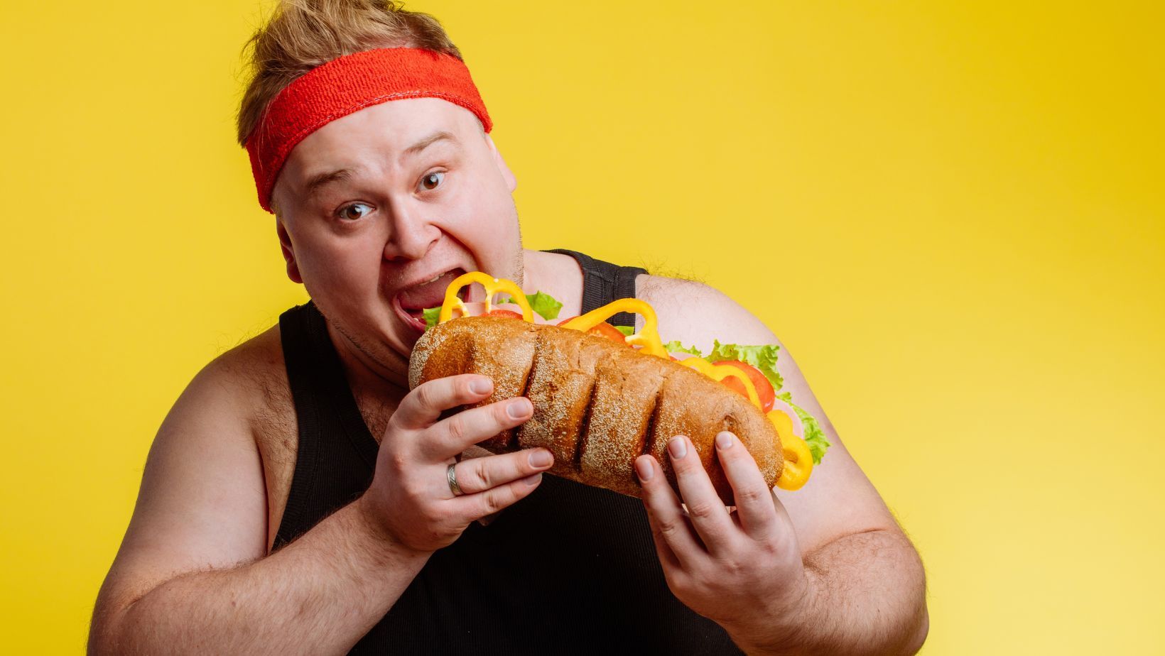 A fat man eating Subway foods.