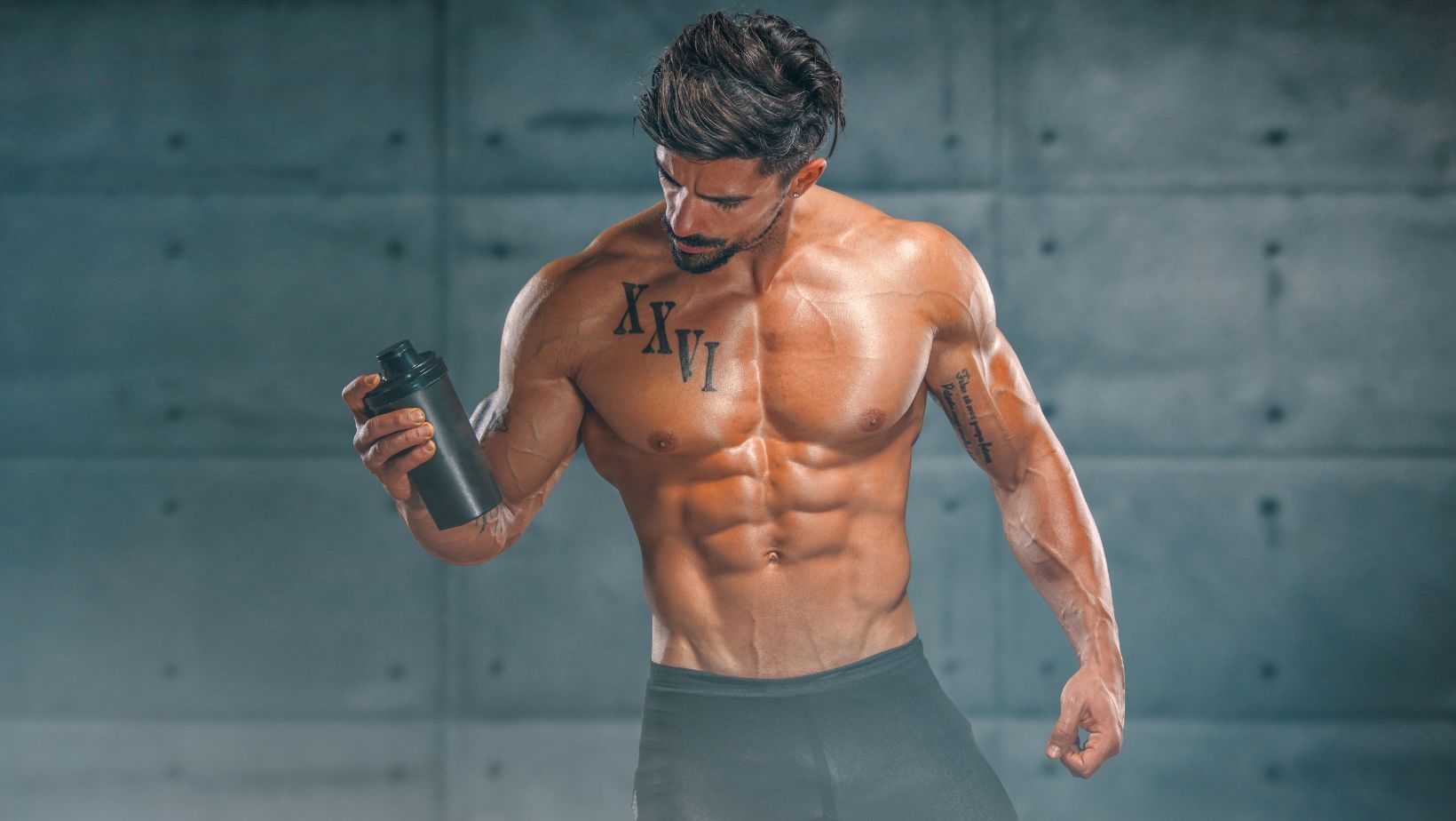 A muscular man holding a bottle of supplements.