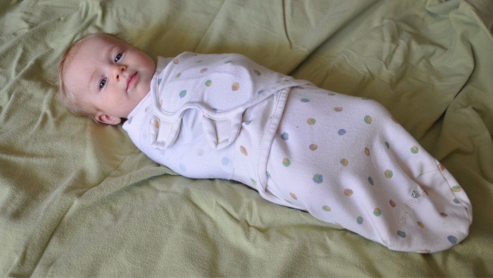 A baby wrapped in a sleep sack.