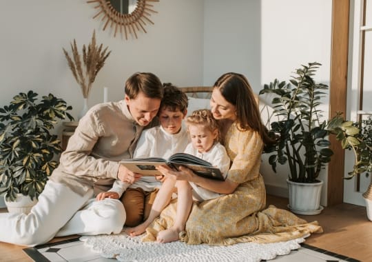 Parents reading a book for their children.