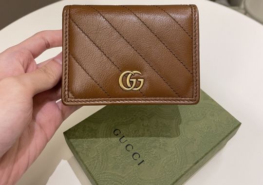 Person holding a Gucci perfume.