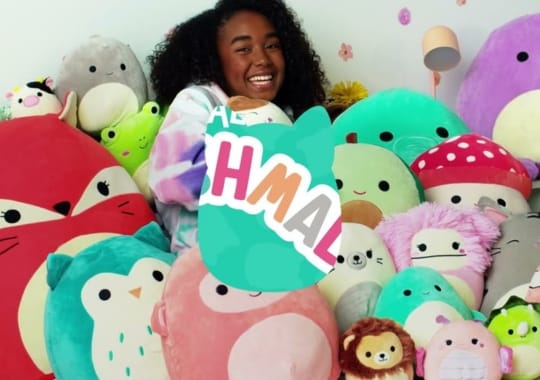 A happy girl with squishmallows.