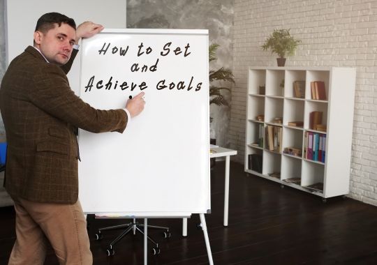 A man illustrating how to set and achieve goals.