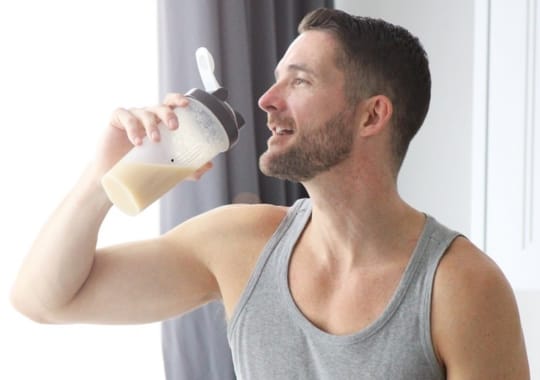 A man holding a bottle of protein shake.