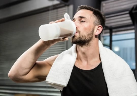 A man drinking a pre-workout supplement.