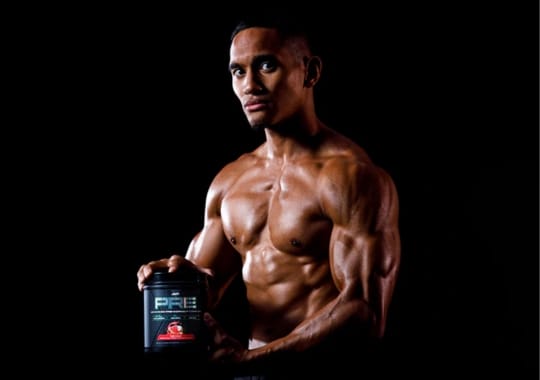 A man holding a pre-workout supplement bottle.