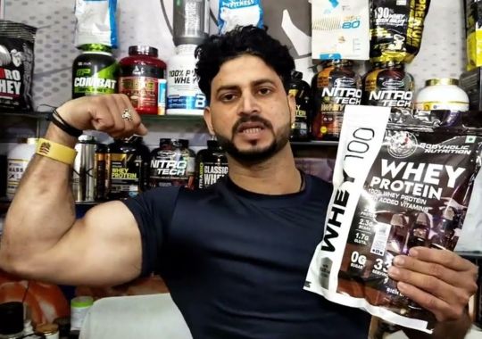A man holding a pack of clear whey protein.