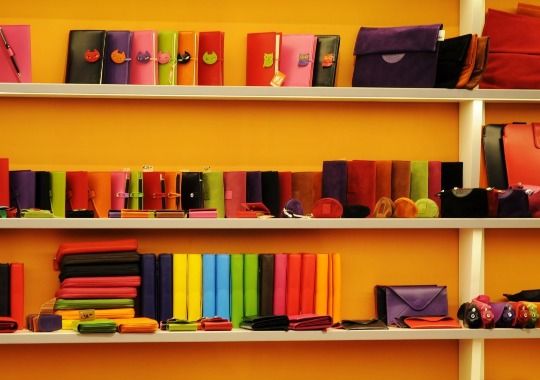 A variety of wallets on a shelf.