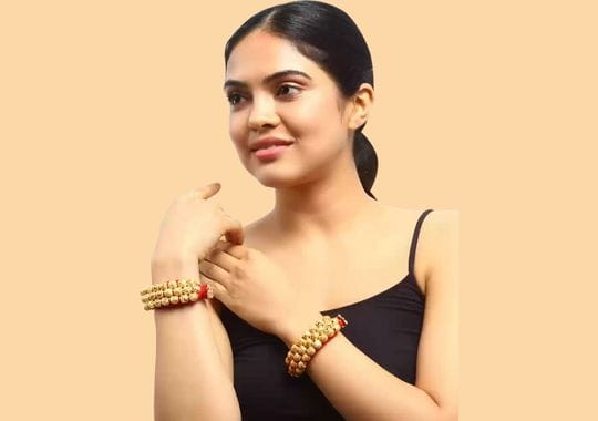 A woman wearing clay bead bracelets.