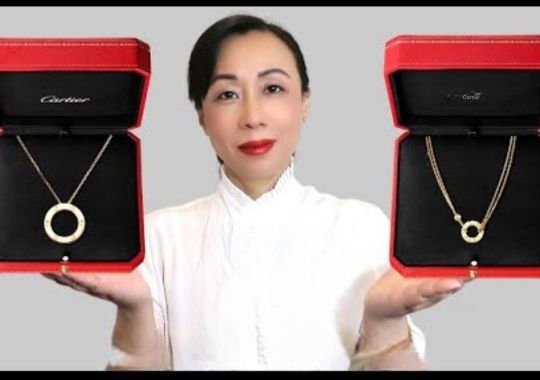 Woman holding two different types of necklaces.