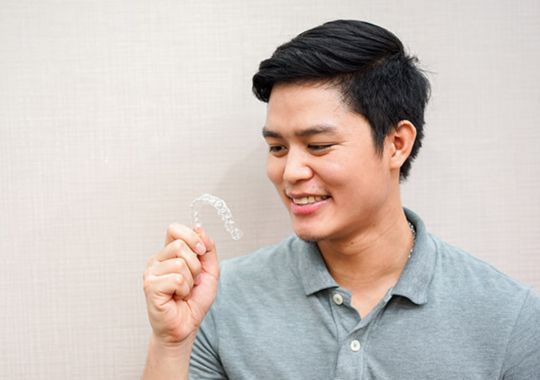A man with invisalign aligners.