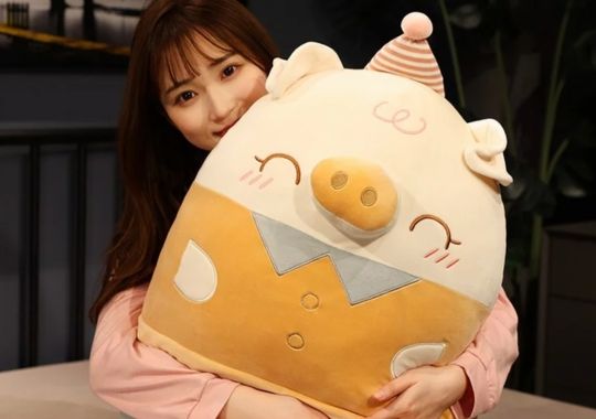 A woman holding a big Squishmallow.