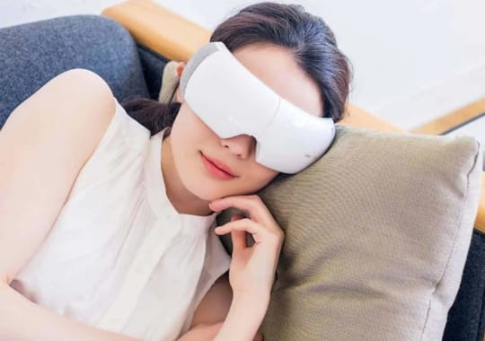 A lady sleeping wearing eye massagers.