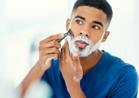 A man shaving his face.