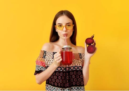 A lady drinking beet root juice.