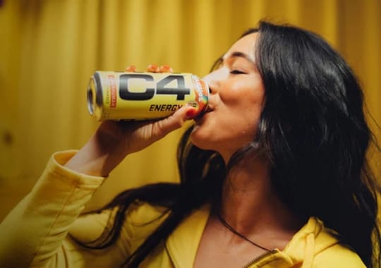A woman drinking a c4 energy drink.