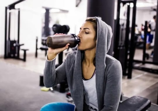 A woman drinking protein shake.