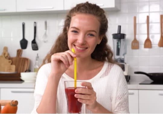 A woman with a glass of beet root juice.