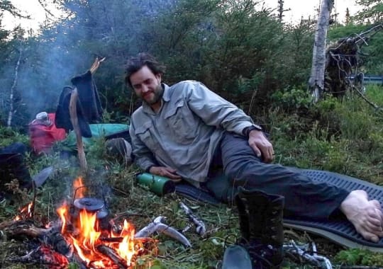 A man camping in the woods.