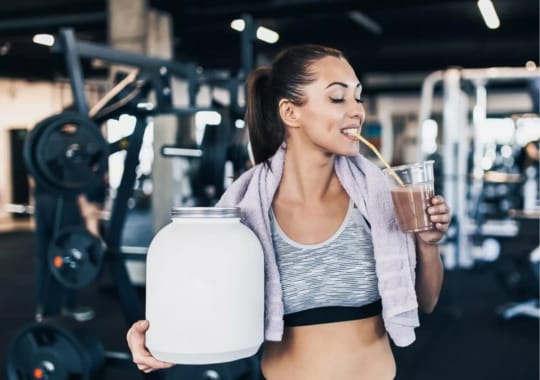 A woman drinking pre-workout supplement.