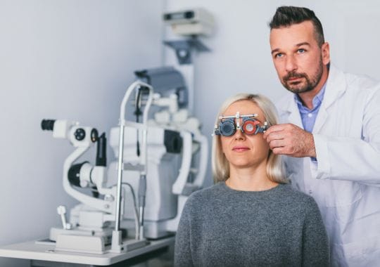 Optician examining woman's eyes.