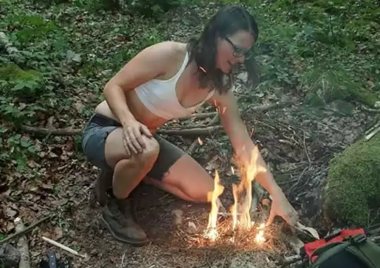 A lady making a fire.
