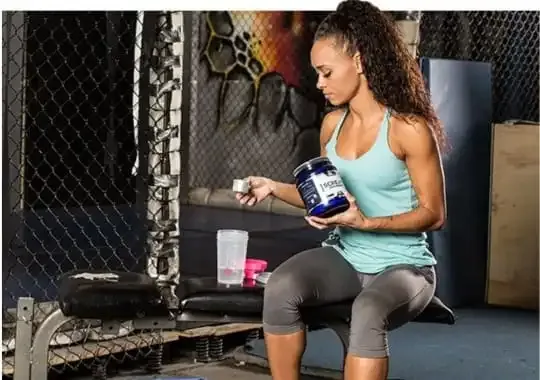 A lady holding a bottle of creatine supplement.