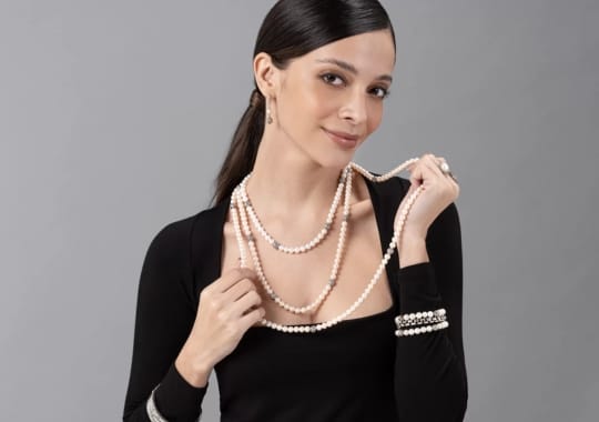 A woman wearing a Chanel pearl necklace.