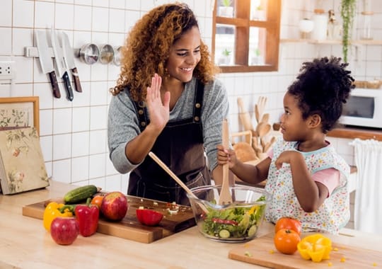 Mother and daughter preparing healthy meals.