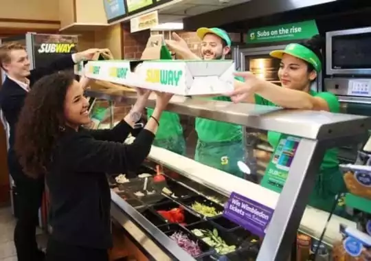 Customers buying sandwiches at Subway.