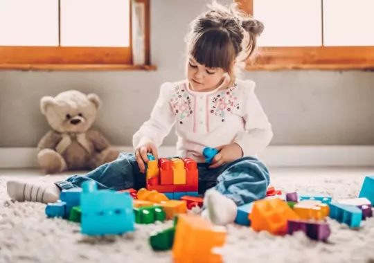 A kid using toys with construction blocks for play.