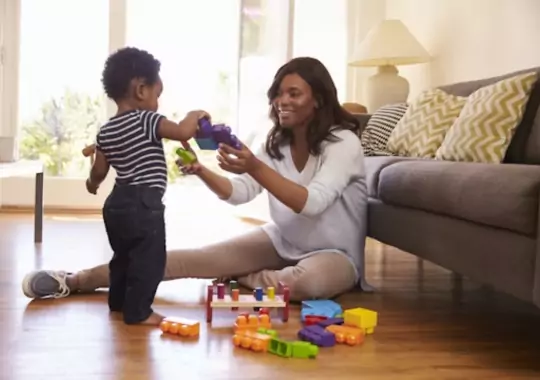 A mother showing her child how to construct with toys.