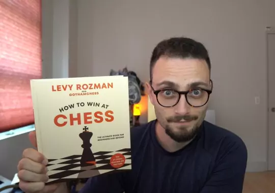 A man holding a chess book.