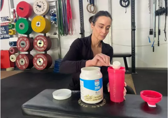 A woman making protein shake for muscle building.