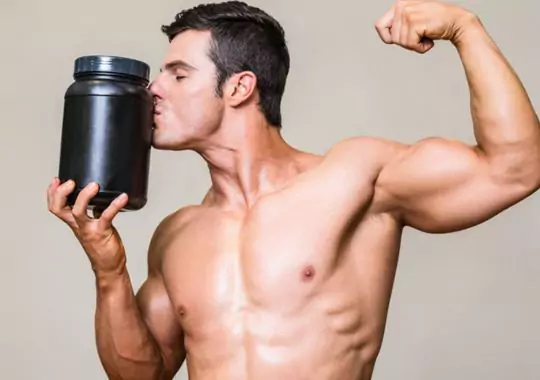 A man holding a tin of pre-workout supplements.