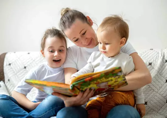A mother reading a book to her children.