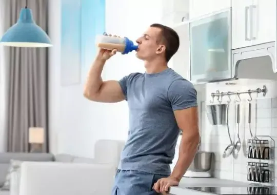 A man drinking a pre-workout supplement.