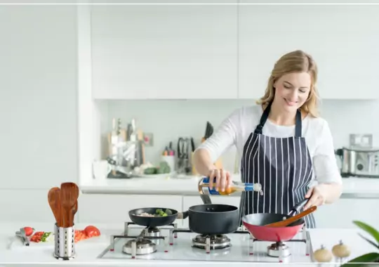 A woman using kitchen utensils to cook in the kitchen.