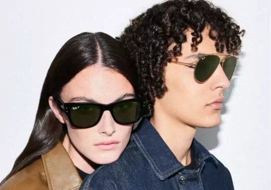 A man and woman wearing pug sunglasses.