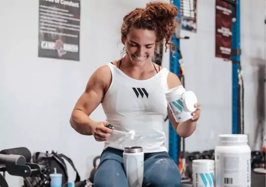 A woman making clear whey protein for muscle gain.