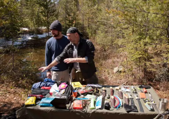 Men with various outdoor survival tools.