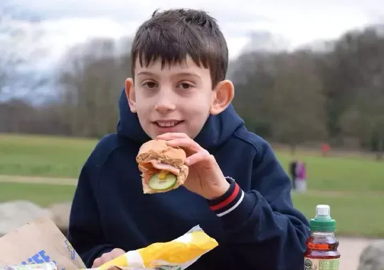 A child eating a subway.