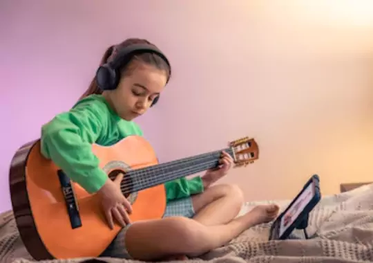 A kid playing a guitar.