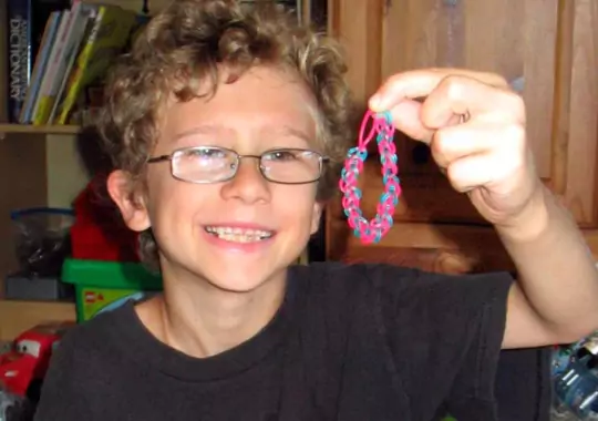 A boy holding a rubber band.