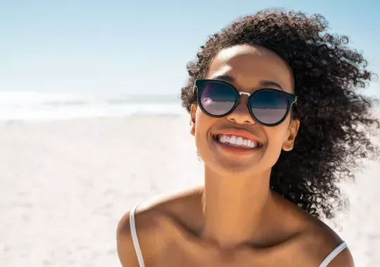 A woman wearing polarized sunglasses at the beach.