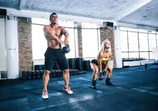 Two people working out in a gym.