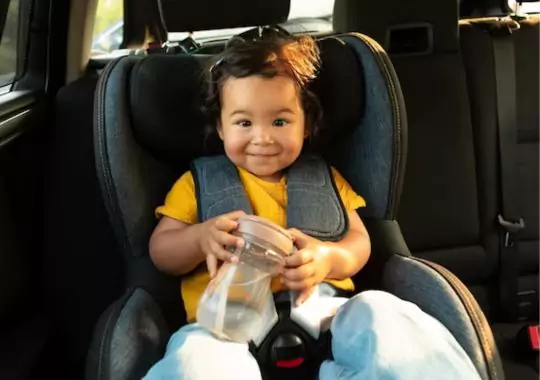 A baby girl seated in a car seat
