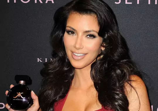 A female carrying a Kim Kardashian perfume bottle.