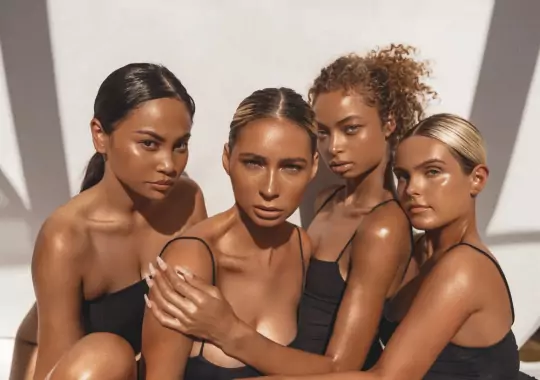 A group of women having spray tan on their bodies.