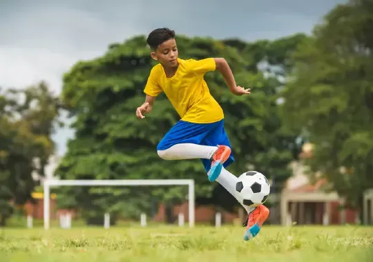 A young boy playing soccer.